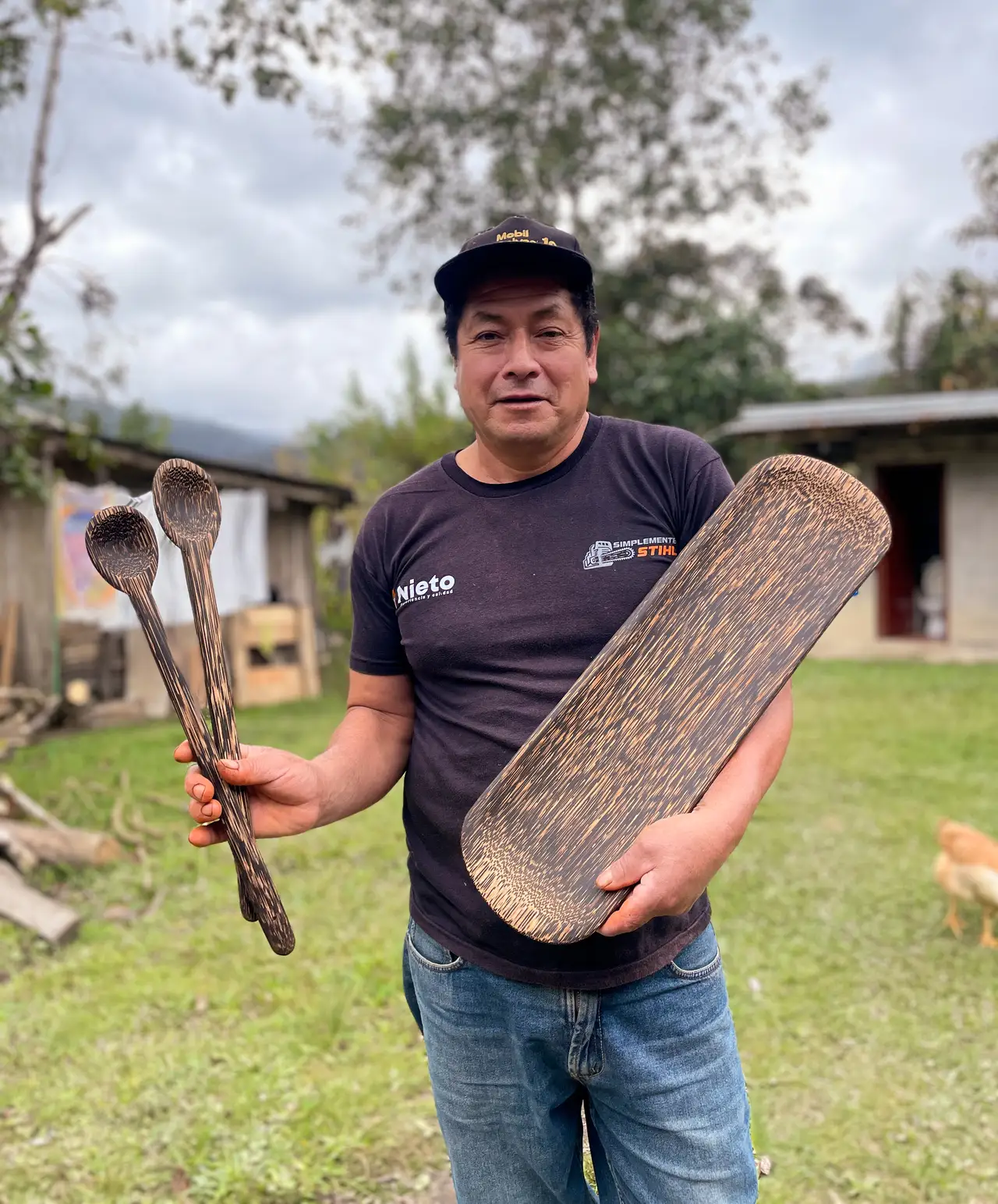 Artesano mostrando una bandeja tallada en madera